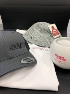 TERMINÉE – Enchère no 15 : plusieurs items, dont un polo de golf blanc, à l&rsquo;effigie de Gravité Média