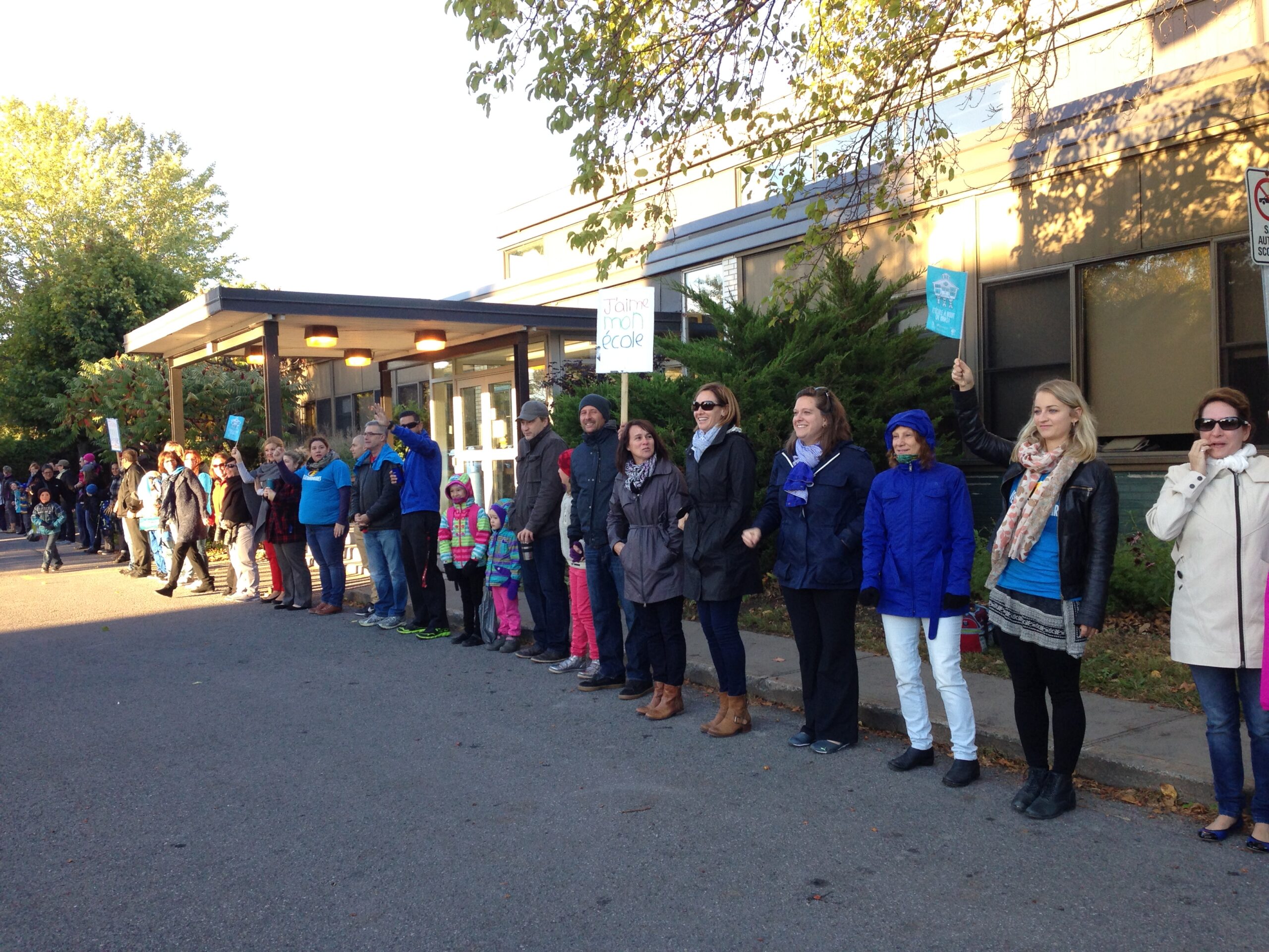 Des parents forment une chaîne humaine devant leur école
